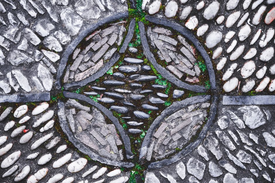 Mandala geïnspireerd tuinpad met gekleurde stenen.